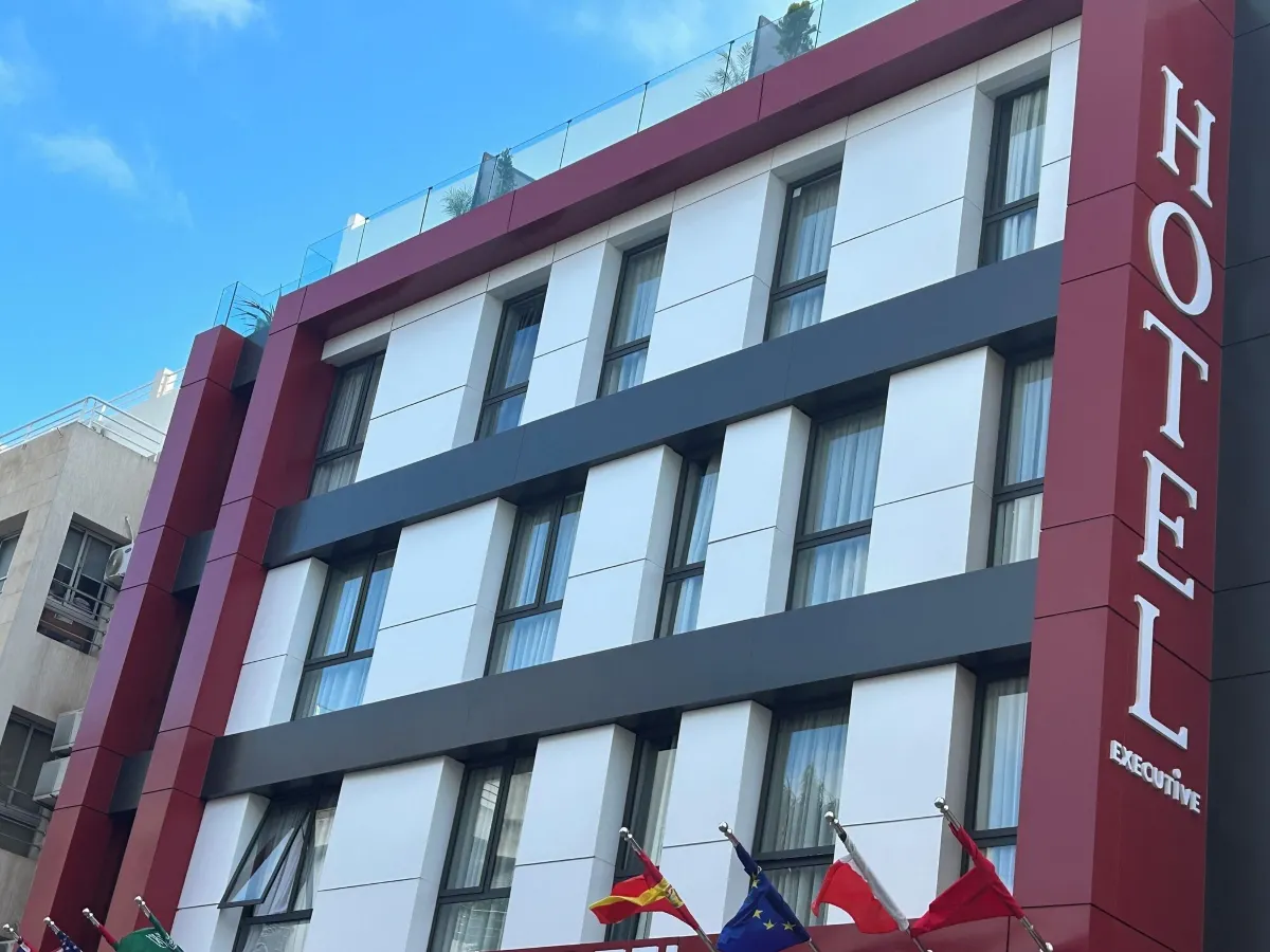 Upward view of the Executive Hotel facade with flags